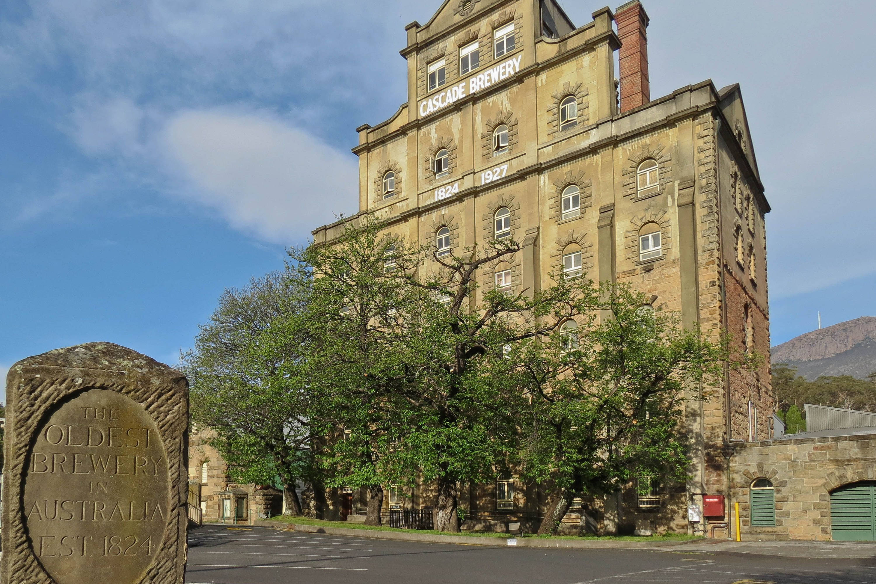 Historic Cascade Brewery building surrounded by greenery at the base of kunanyi / Mount Wellington in Hobart, Tasmania.