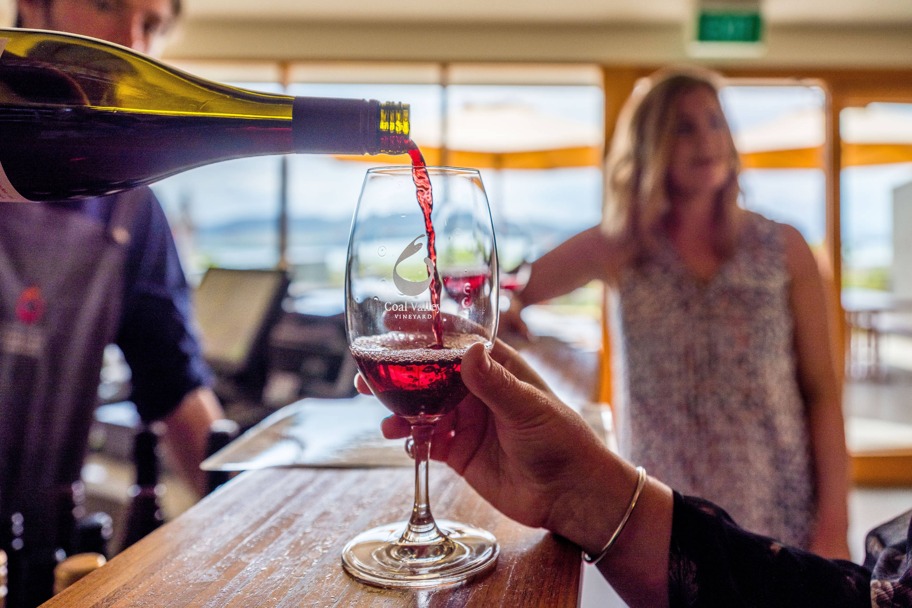 Pouring a glass of red wine inside the tasting room at Coal Valley Vineyard.