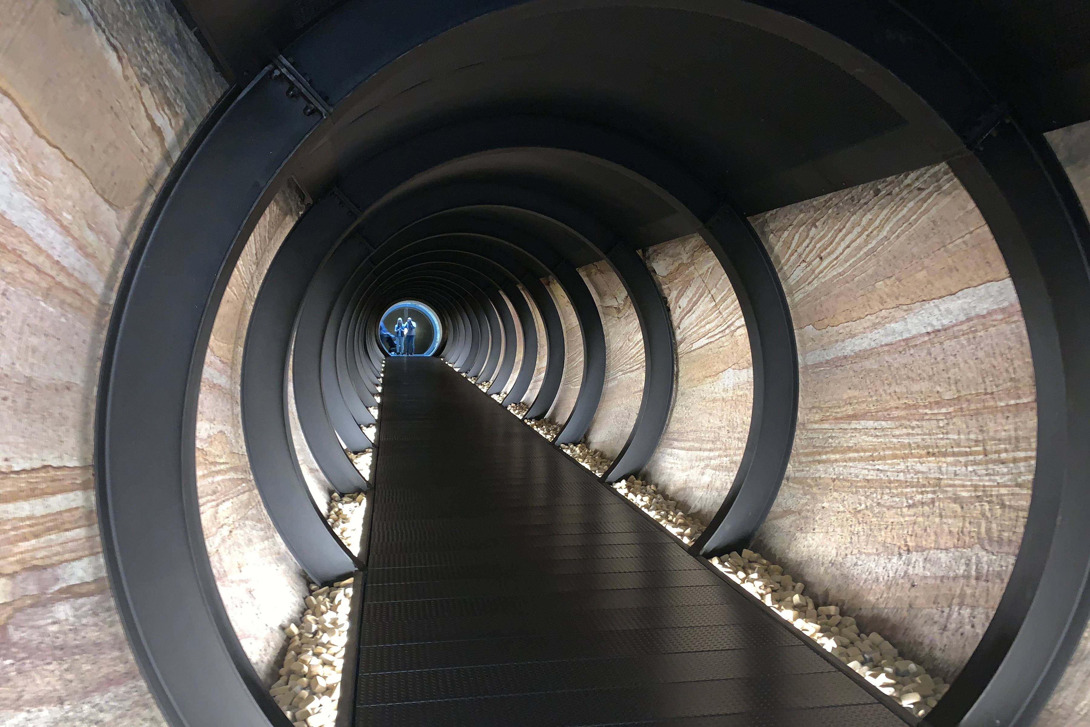 Circular tunnel with exposed sandstone walls at Mona which forms part of the Siloam tunnel network, connecting gallery spaces.