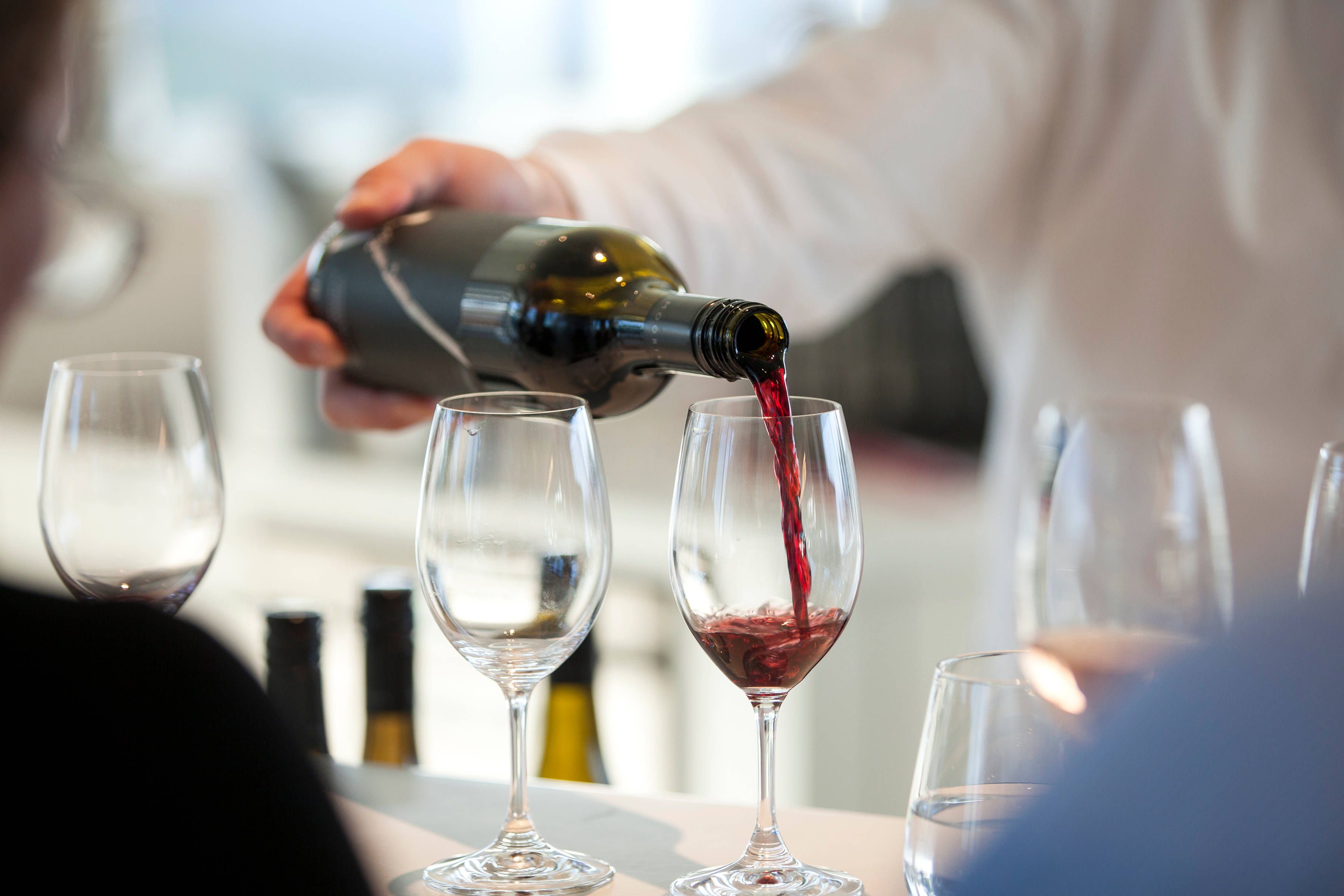 Bottle of red wine being poured by a staff member as part of a wine tasting at Moorilla.