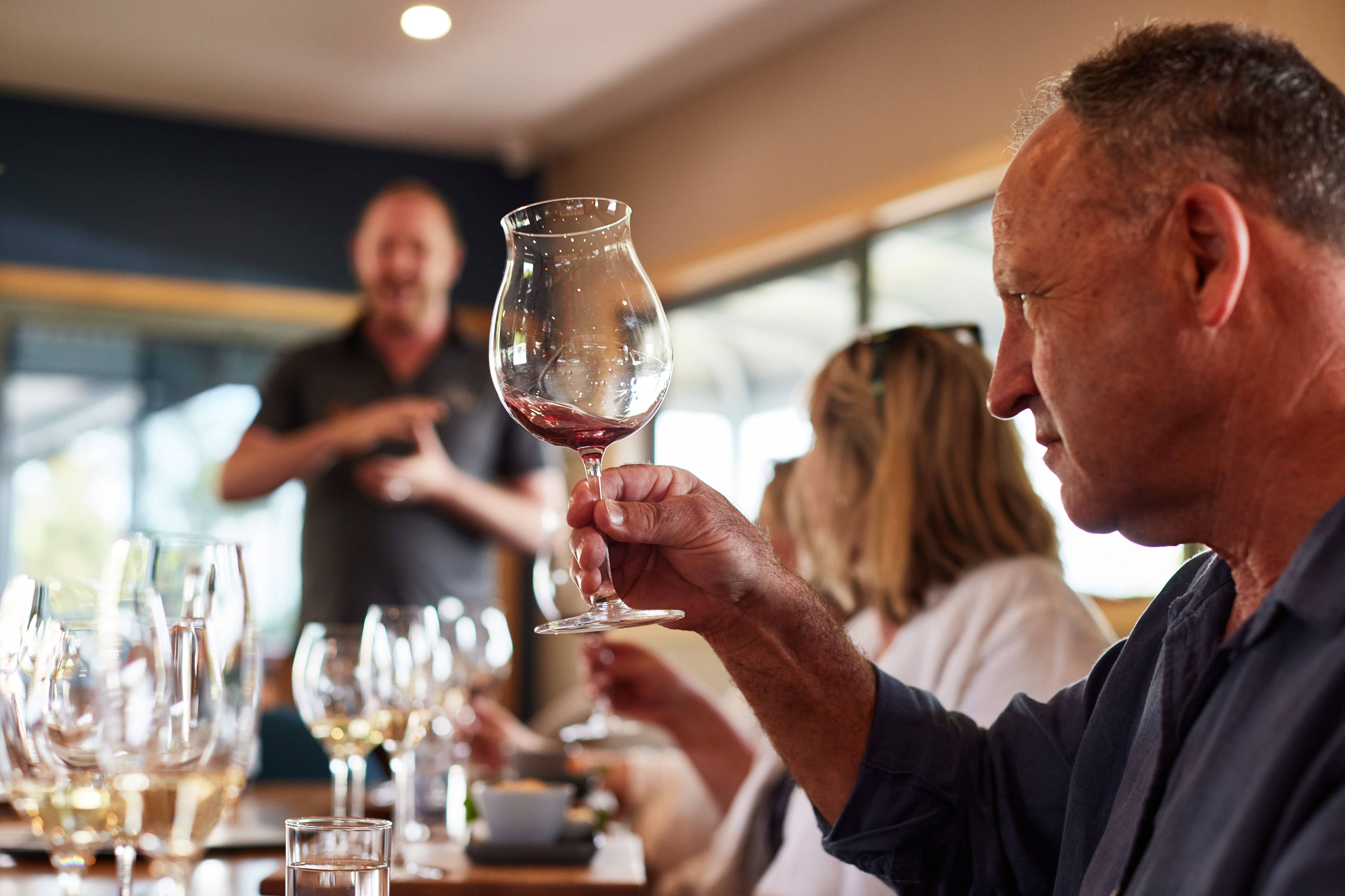 Man inspecting a glass of red wine at Puddleduck Vineyard.