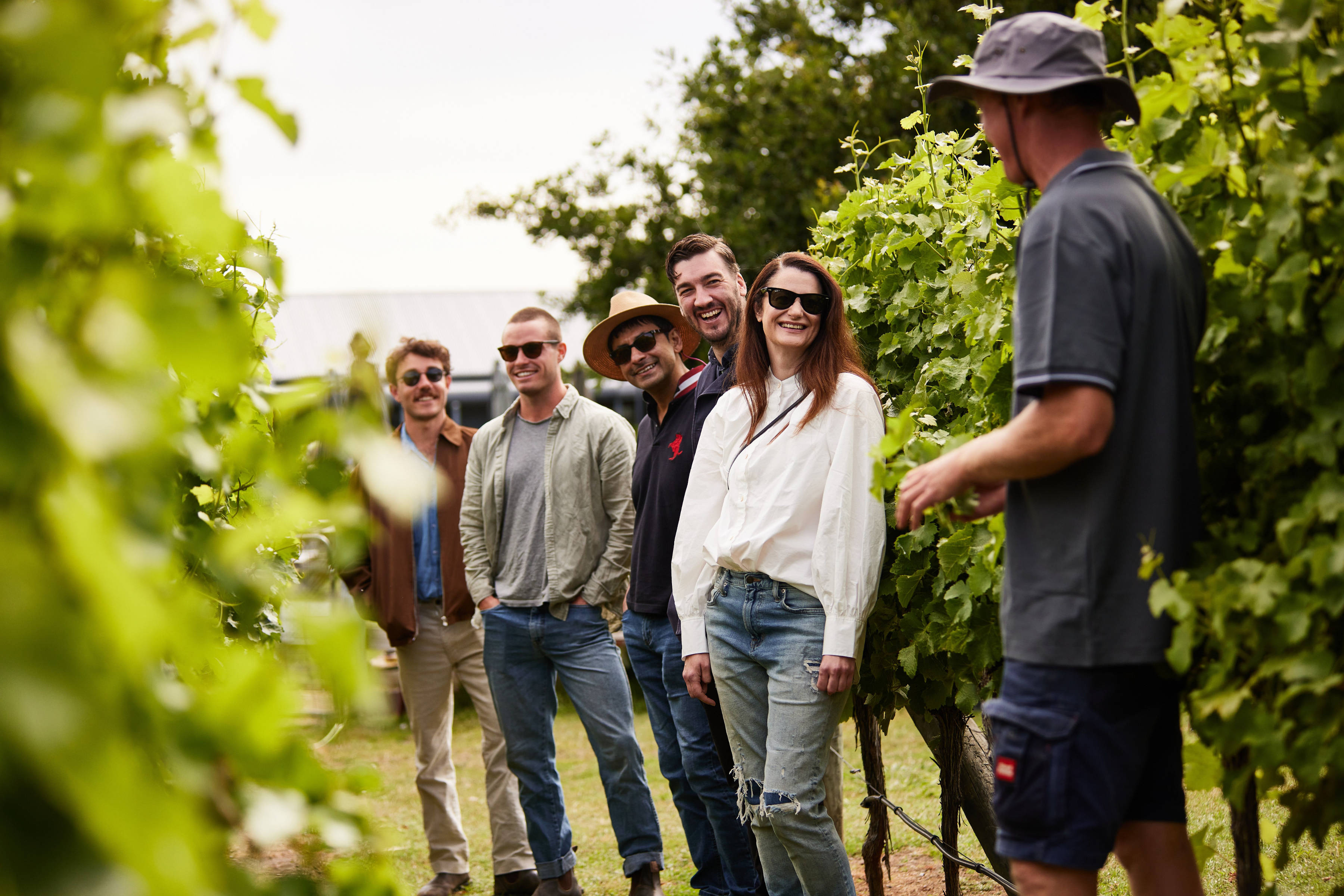 Group of people on a tour amongst the vine-covered rows at Puddleduck Vineyard.